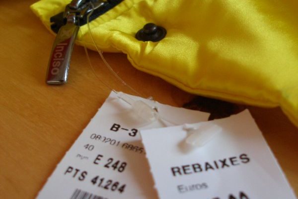 Detall de l'anorak groc amb les etiquetes de rebaixes: de 248 euros a 115