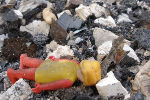 Click de Playmobil molt brut estirat bocaterrosa sobre pedres i cendra