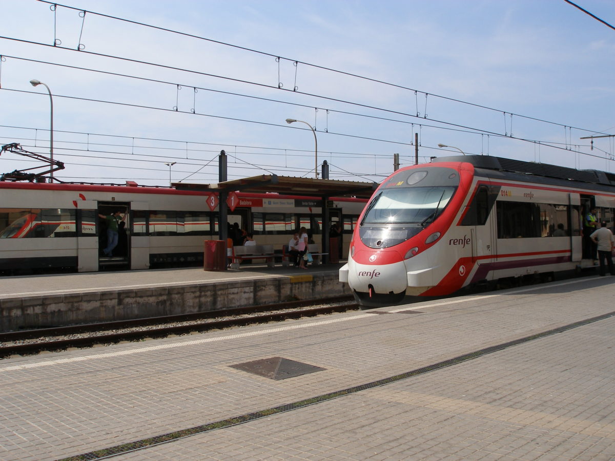Estació de tren de Badalona, amb un tren en primer terme i una aparcat a la via del fons