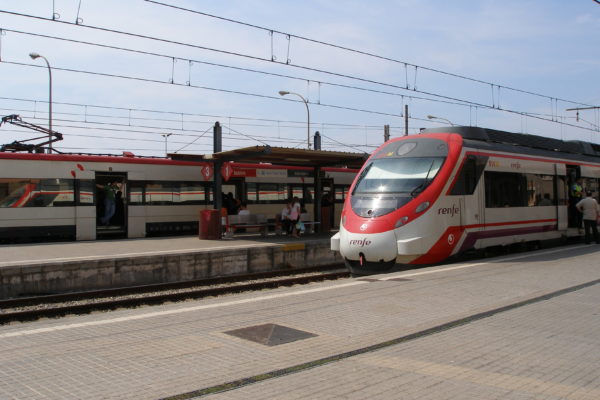 Estació de tren de Badalona, amb un tren en primer terme i una aparcat a la via del fons