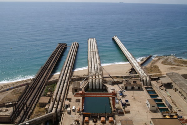 Tubs llarguíssims que s'endinsen al mar vistos des de dalt d'una de les xemeneies