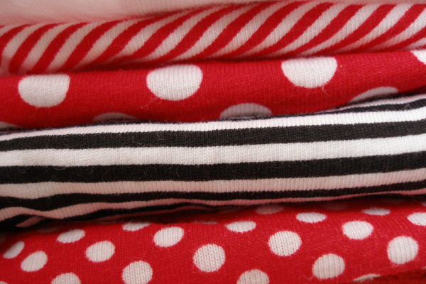 Detall dels estampats d'una pila de calcetes blanques, vermelles i negres: ratlles i topos