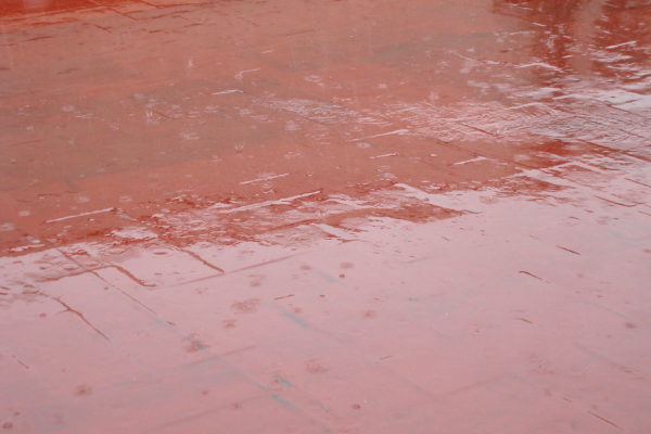 Terra del terrat de color vermell on hi cauen gotes de pluja