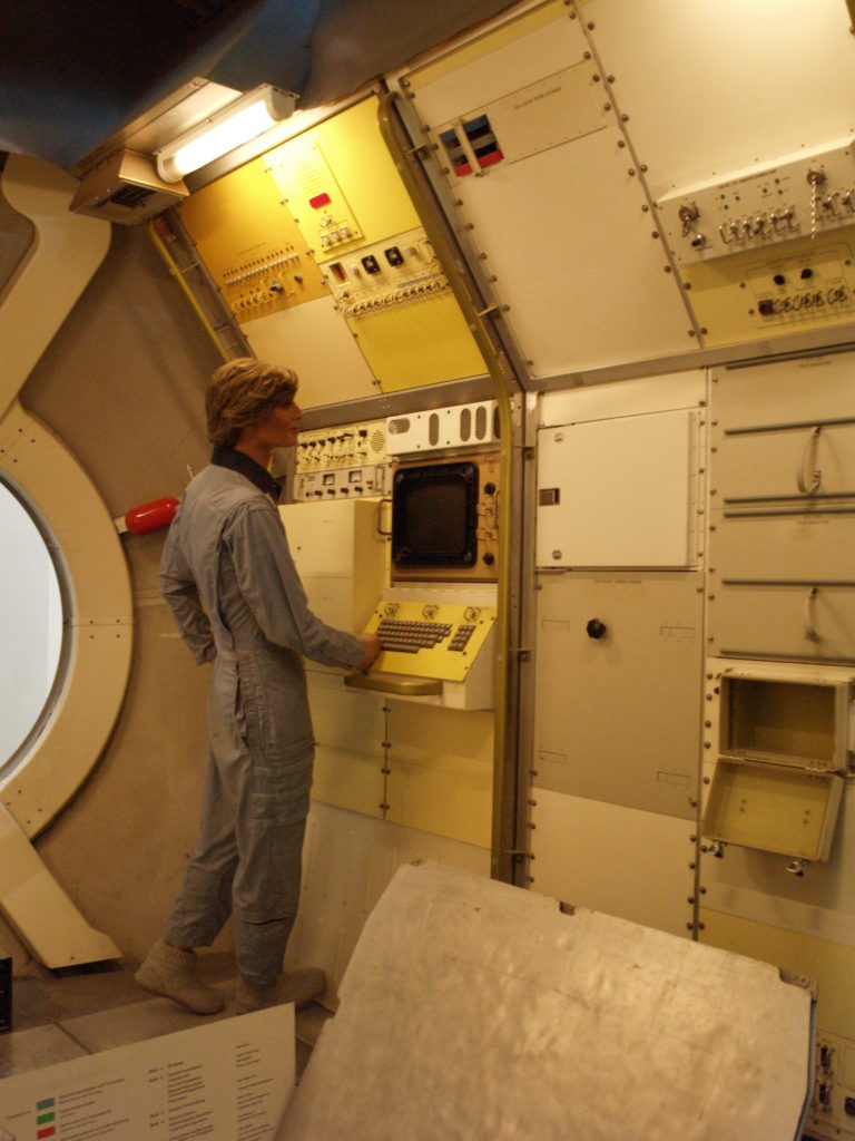 Maniquí davant un ordinador d'una nau espacial molt antiga