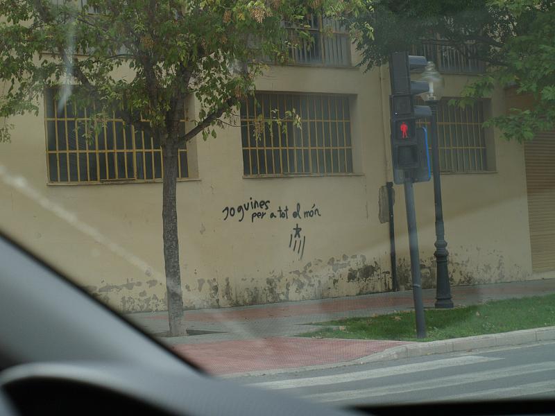 Façana amb un grafitti que demana "Joguines per a tot el món"