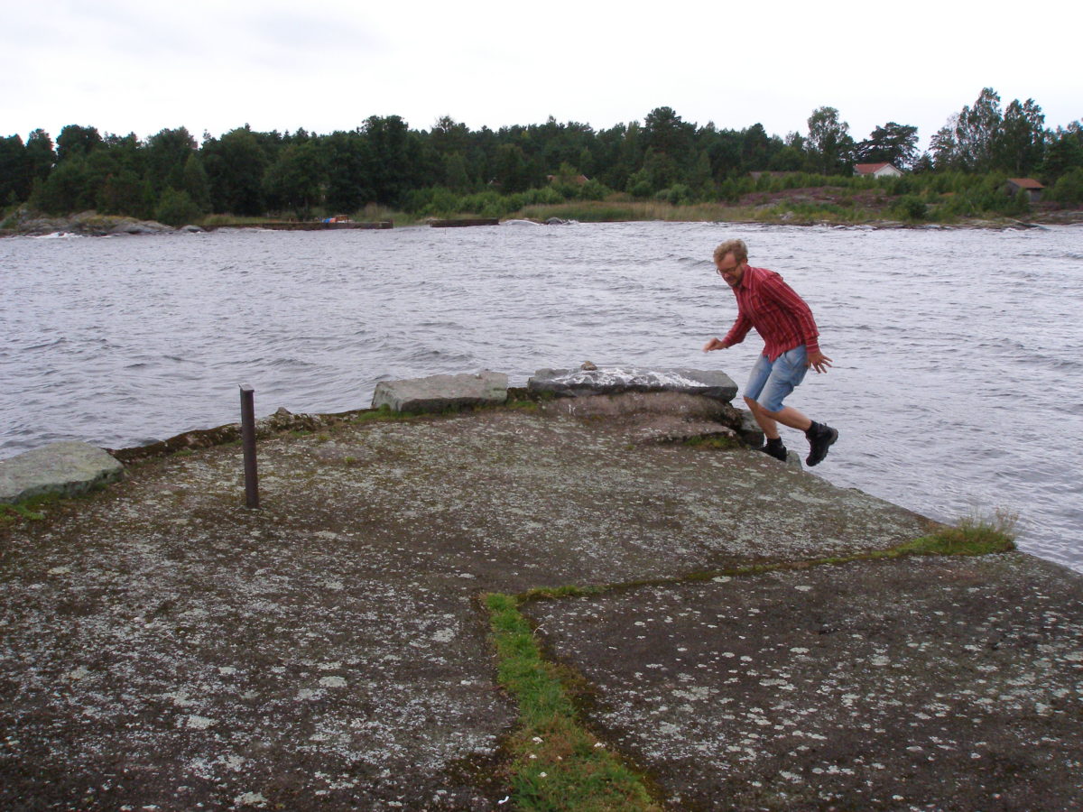 Dani pujant a una estructura de ciment, amb el llac de fons