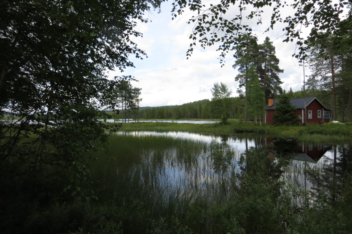 Racó amb un llac i reflexes de l'entorn a l'aigua, amb una casa típica al fonsa la dreta