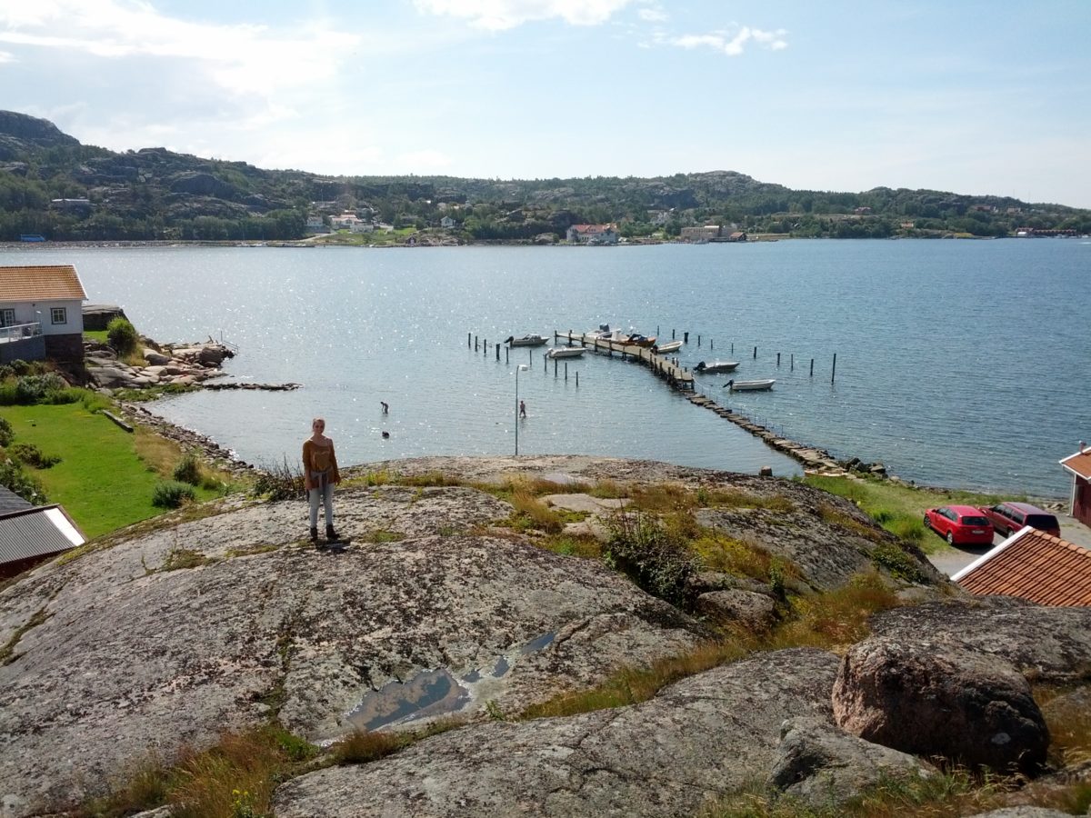 Vista del mar amb un embarcador des de dalt amb una gran roca en primer terme