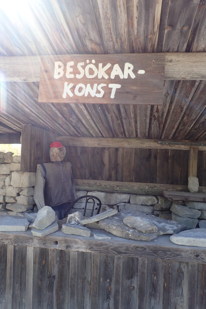 Taulell amb trossos de pedra i un vigilant també de pedra, disfressat