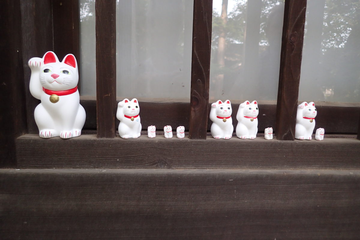 Detall d'una finestra del temple de Gotokuji amb maneki nekos