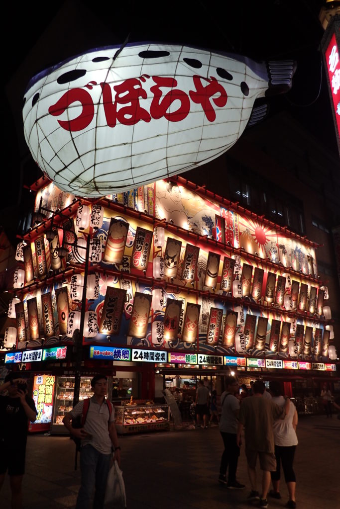 Façana d'un restaurant de Shinsekai il·luminada amb un peix gegant davant