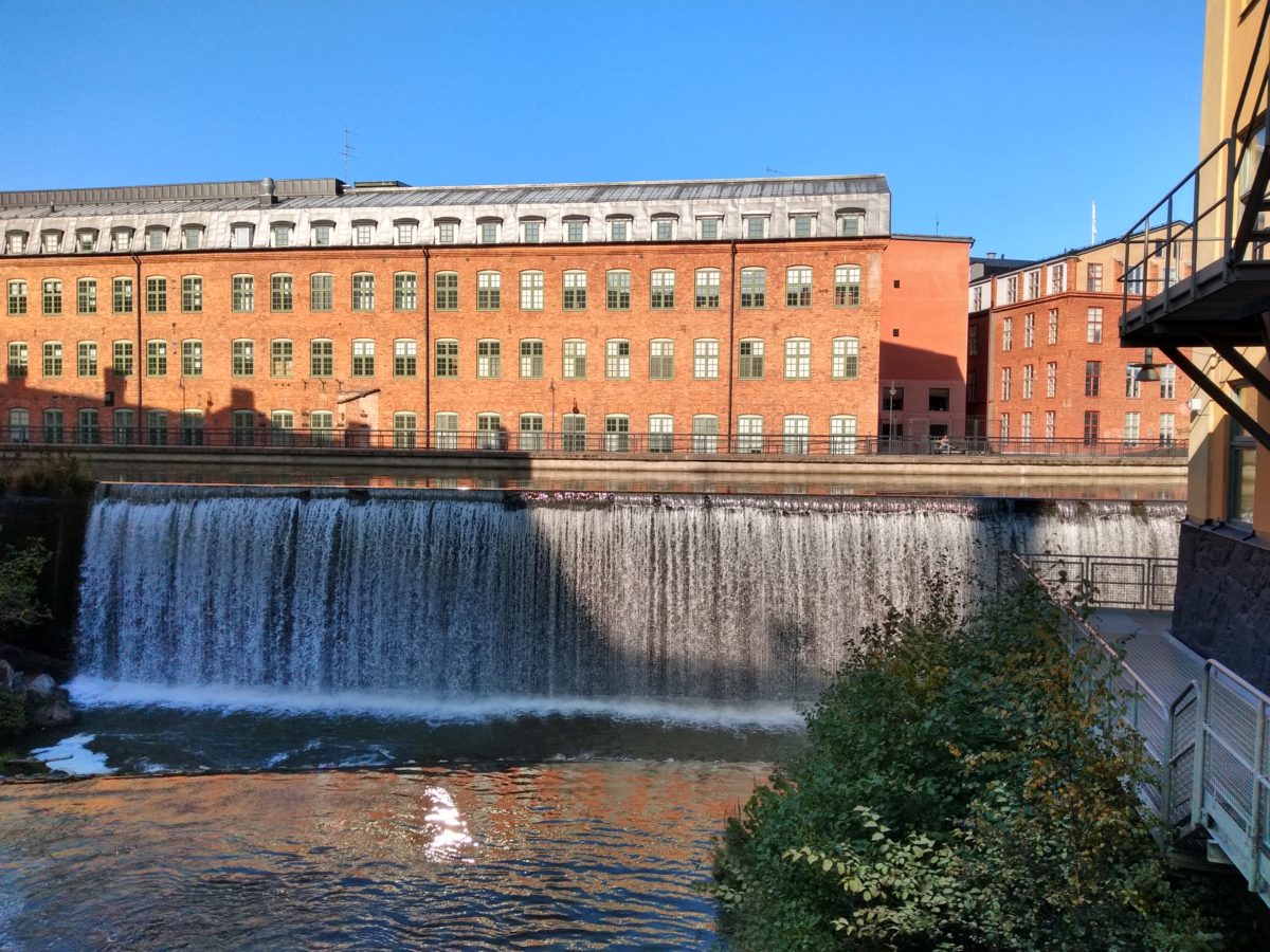 Una cascada amb un edifici al fons