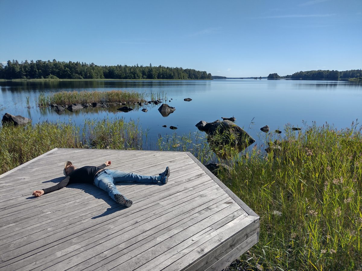 Dani en posició de narcolèpsia sobre una plataforma de fusta i el llac de fons